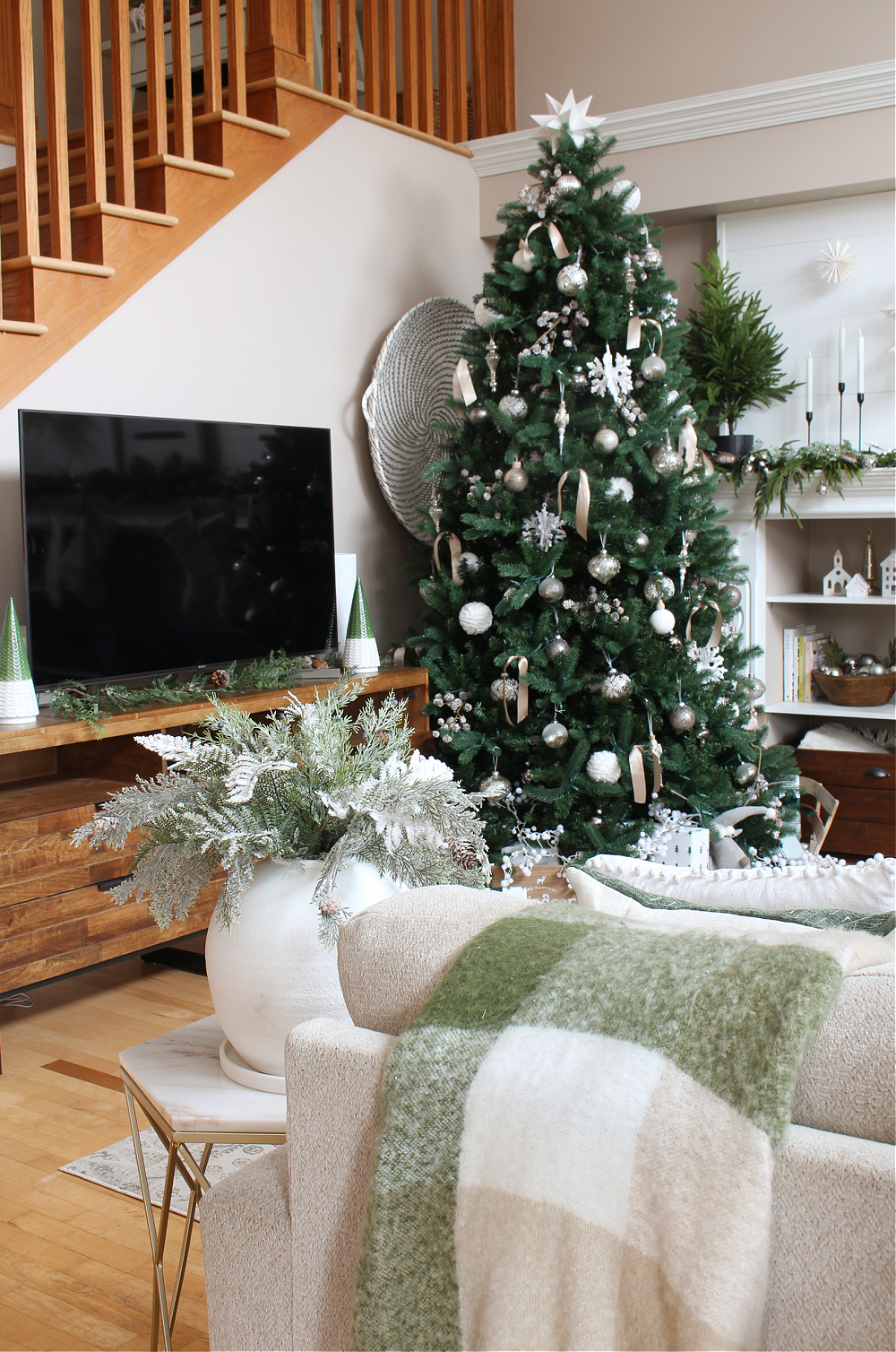 Cozy living room decorated for Christmas with white and green,