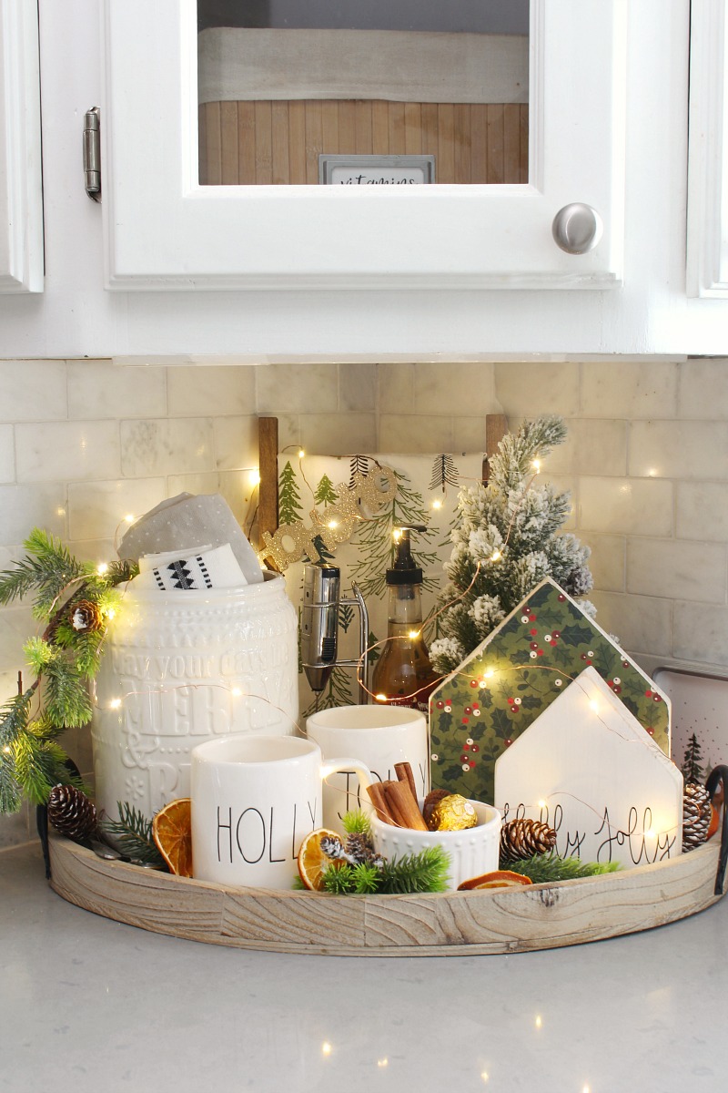 Christmas beverage bar in the kitchen with pretty Christmas lights.